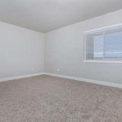 Carpeted primary bedroom with large window and ample outlets at Parc at Prairie Grass, located in Colorado Springs, CO